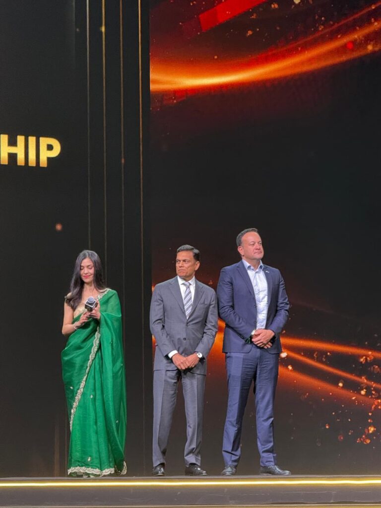 Three presenters on stage at formal event
